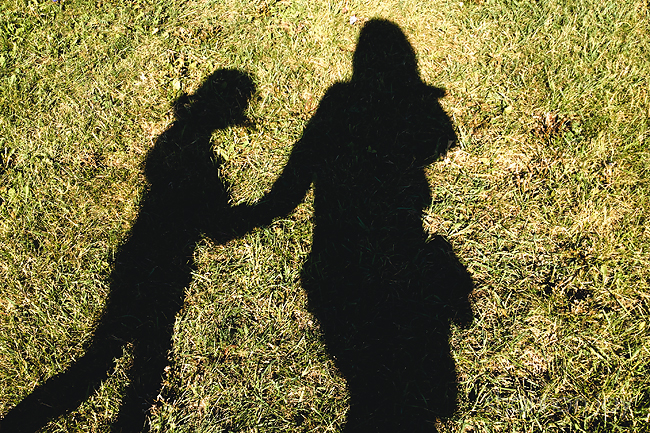 Shadow of a child and adult holding hands on the green grass taken during project 365.