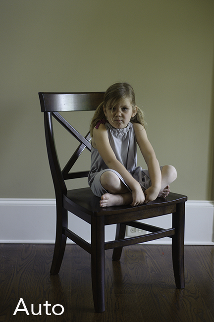 Photo of child sitting in a brown chair showing auto white balance.