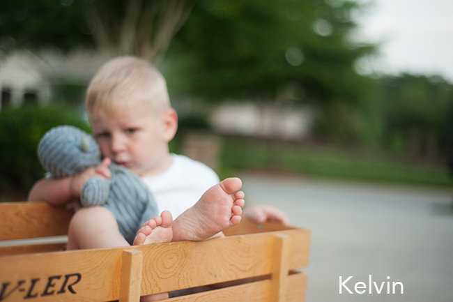 photo of a child sitting in a wagon, feet in focus.