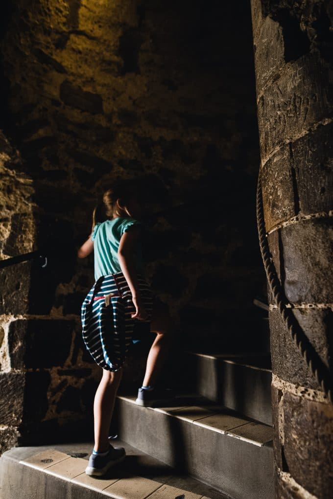 Child walking up old castle stairs in a low light condition using ISO an exposure tip photography