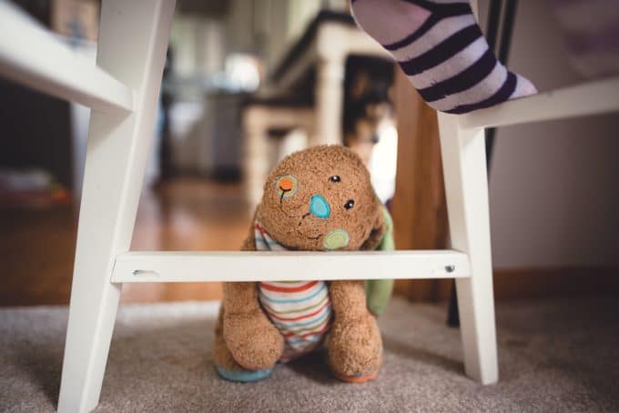 Stuffed animal sitting under child's feet. Photography for kids is a fun activity for all.