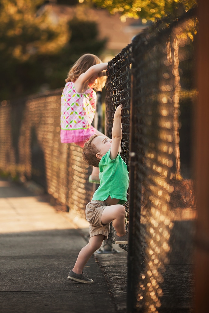 children climbing a fence with the fence acting as a leading line