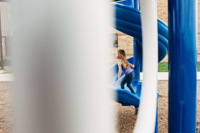 Example of framing using a play ground showing a child climbing up a blue slide. 