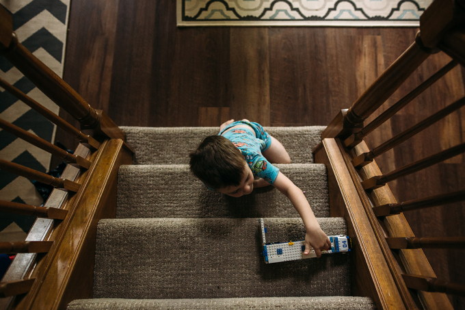 Child playing with a toy truck on a staircase.