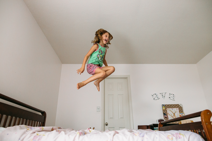 Documentary photography style shot of a child jumping on a bed