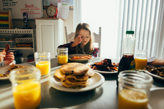 Documentary photography style shot of a child eating breakfast 