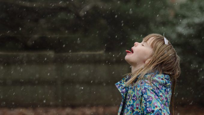 Child catching a snowflake on their tongue in a candid photo
