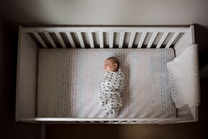 newborn asleep in crib during a lifestyle newborn photography session