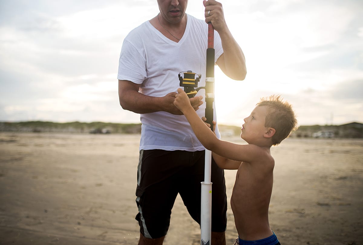 photo of dad and son putting together a fishing pole