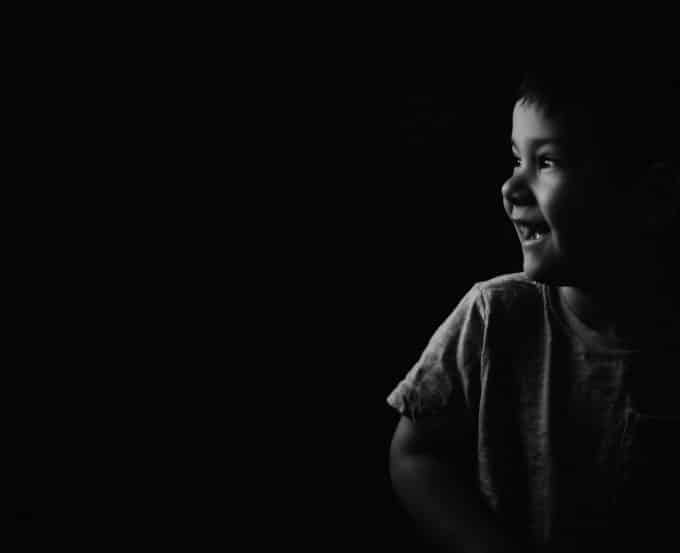 child in low light with negative space