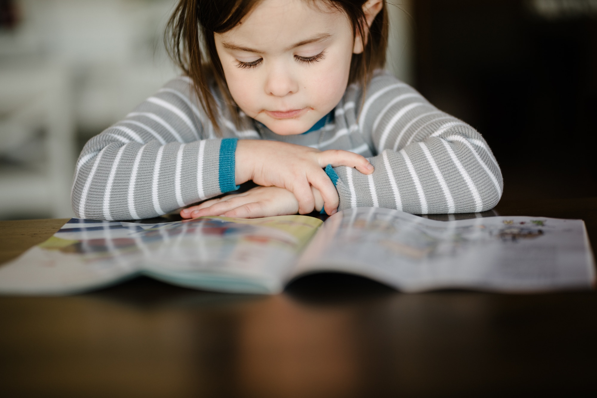 Child reading a book using indoor natural light