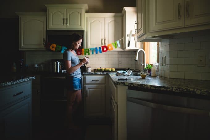 self portrait of woman in kitchen icing cupcakes using indoor natural light