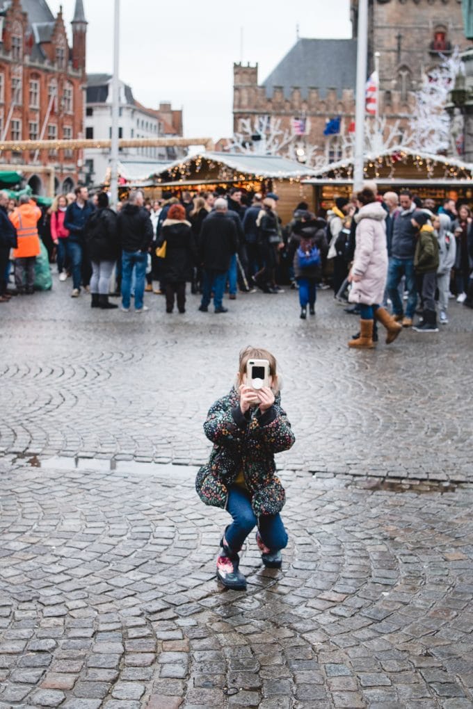Child holding phone taking a picture. photography for kids.