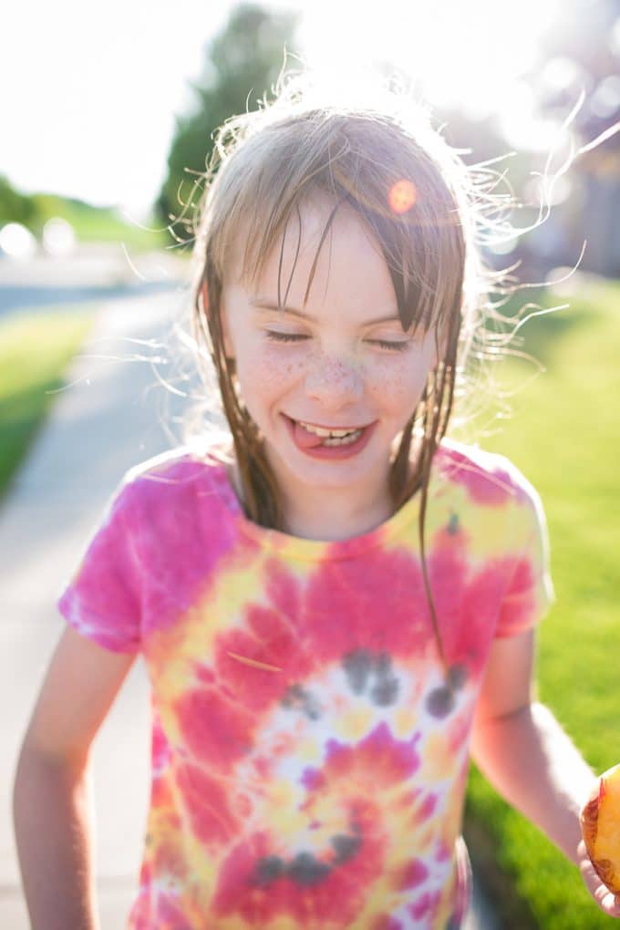 Child in Tie dye shirt with golden sun backlighting during summer for summer photography tips