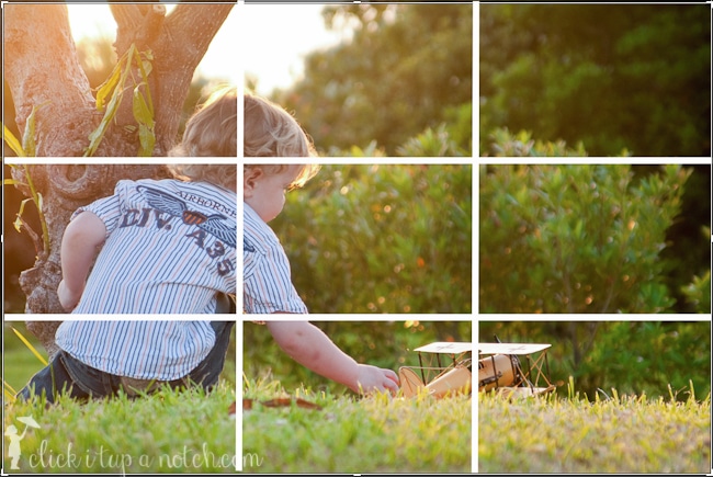 Child playing with airplane with a grid overlay on the top of the image to demonstrate a rule of composition in photography called rule of thirds.
