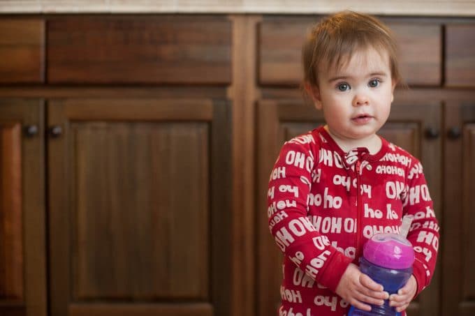 Child wearing christmas pajamas standing in the kitchen with milk cup. 35mm vs 50mm comparison using the 50mm for beautiful portrait. 