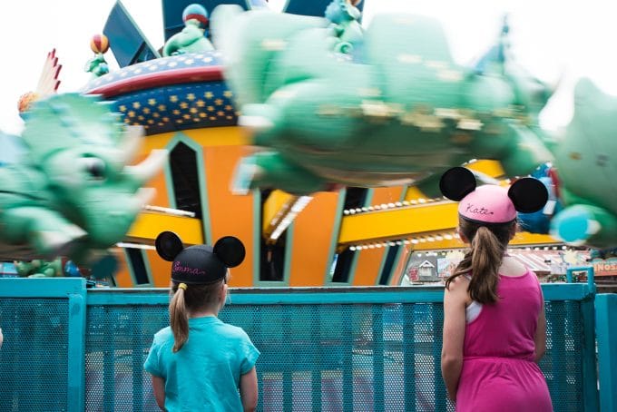 A ride at Disney with two children standing in front wearing mickey hats with their names across the back. The photo was taken with a 24-70mm lens
