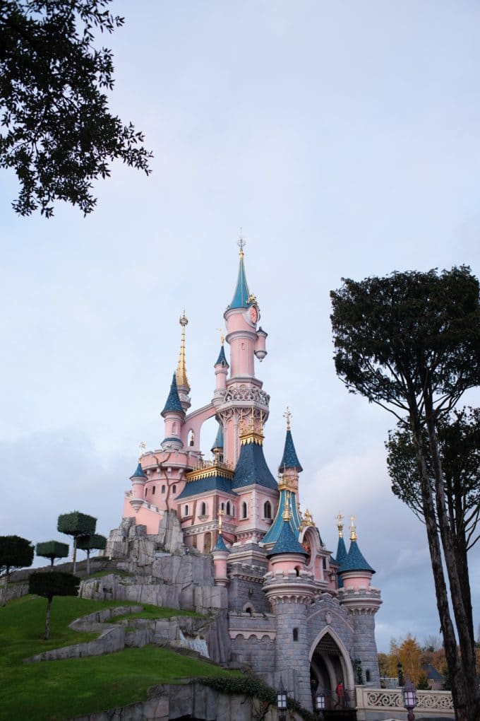 A pink Disney castle with a blue roof.